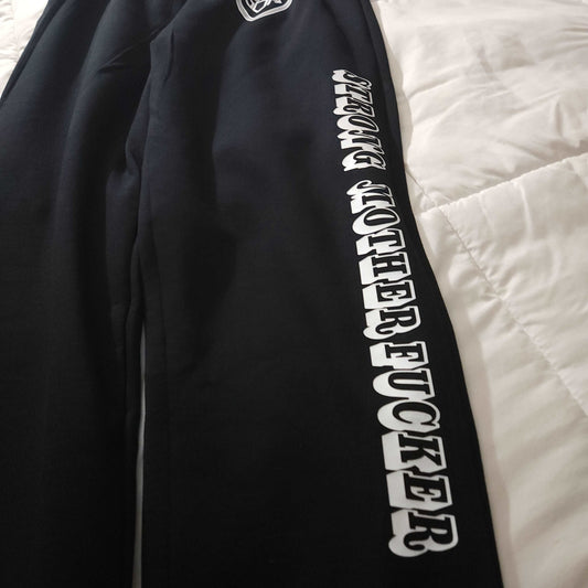 black sweatpants with a white drawstring waist and 'strong mother fucker' in collegiate-style script on the left side. Available in sizes small to 3x, these sweatpants are the perfect combination of style and comfort. The open bottom design ensures ease of movement, while the drawstring waist allows for a customized fit. These sweatpants provide both physical and emotional comfort, reminding you of your strength and resilience